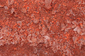 A winter ice puddle in a severe frost. Red oxidized soils with puddles in winter