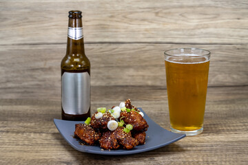 Teriyaki marinated wings arranged with perfect presentation served with a pint of draft beer as Vietnamese Cuisine