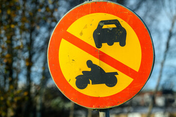 A circular sign indicates that cars and motorcycles are prohibited in the area. The bright colors...