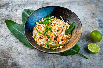 Authentical Asia style ramen noodle soup with prawns and cashew nuts served as close-up in a design...
