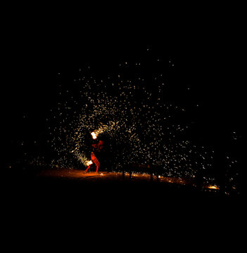 Cracheur de feu avec arc de cercle et socle de terre ocre avec de multiples projections dans le ciel tourbillonnante 
