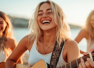 A young blonde woman playing the guitar on vacation with friends at the beach, laughing and enjoying music together