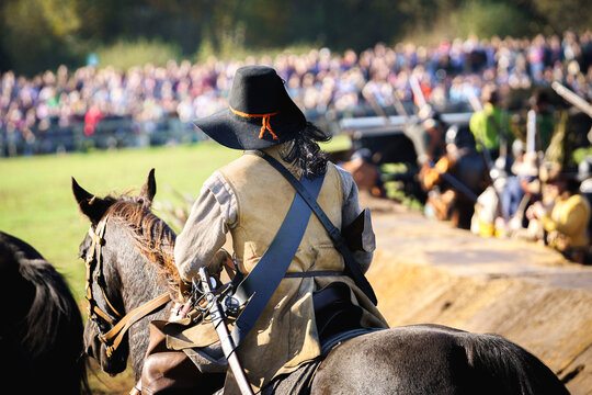 Historical medieval dragoon on horseback riding on the battlefield. An infantryman who moved on horse ("mounted") and fought on foot ("dismounted"). .