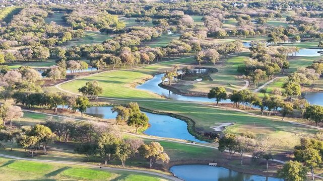 Aerial view of golf course fairway landscape with trees in Dallas-Ft. Worth (DFW) Metroplex during morning sunrise 