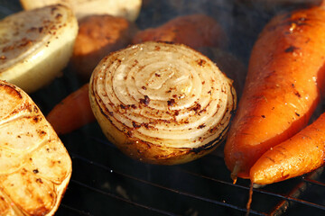 Grilled vegetables cooking on a barbecue grill with smoke