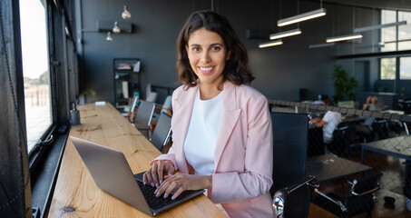 Portrait 30s latin hispanic business woman manager working on laptop computer in modern office....