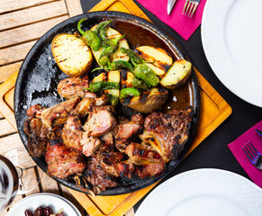 Serving of grilled beef with potatoes and spicy pepper on side