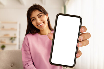 Greeting Concept. Portrait of smiling beautiful woman waving hello with hand looking at camera, using laptop at home office. Cheerful lady saying hi or goodbye during video call, blurred background