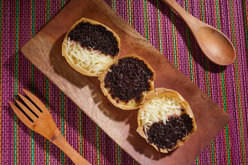 Martabak mini or terang bulan mini is Indonesian popular street food, made from flour, egg, yeast, topped with cheese or chocolate. Mini sweet martabak placed on a rainbow-colored mat