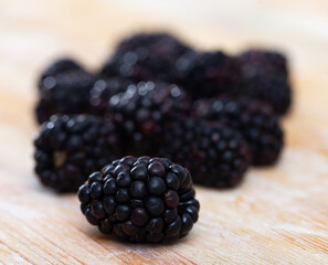 Sweet vitamin dessert snack - black large mulberry berries are on table. Bunch pile of ripe...