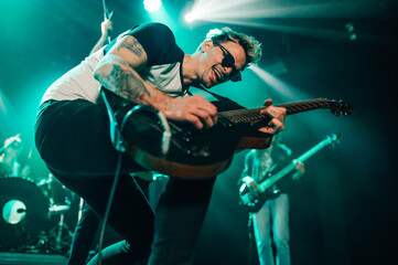 Guitarist performing energetically on stage during concert