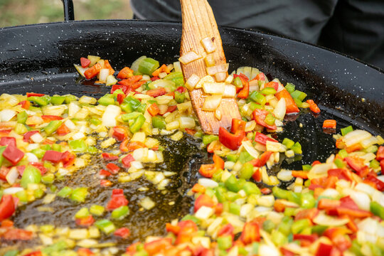 fried red and green peppers with garlic and onion for a Spanish rice recipe, sofrito. mediterranean gastronomy concept background