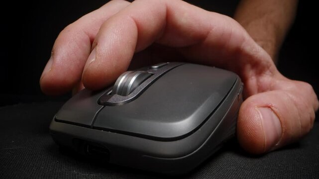 Close-up of a hand gripping a computer mouse, showing ergonomic design and control, emphasizing usability and comfort for efficient navigation.