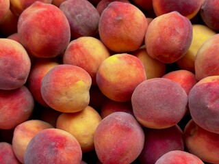horizontal background of ripe peaches, fruit gathered together in a pile and ready to eat