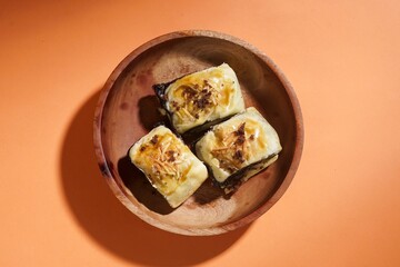 Banana bolen is made from banana and pastry skin and has chocolate and cheese filling. Served in wooden plate. Selective focus image.