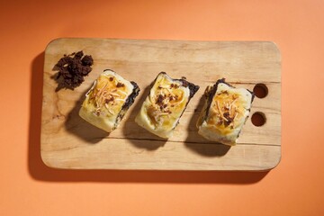 Banana bolen is made from banana and pastry skin and has chocolate and cheese filling. Served in wooden plate. Selective focus image.