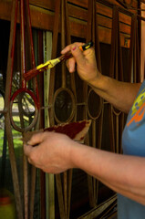 woman painting the bars on her kitchen window
