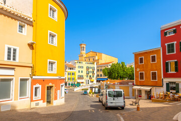 Fototapeta premium Colorful and picturesque streets in the hilltop city of Mahon or Mao, Spain, on the Mediterranean island of Menorca, with the Santa Maria church in view.