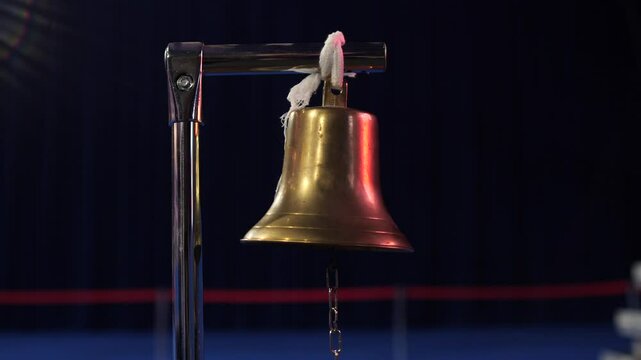 close up of a boxing referee hitting the boxing bell with a hammer mallet