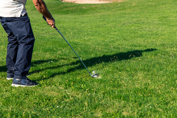 Fototapeta premium senior golfer unrecognizable striking the ball during tournament