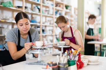 Teenagers are interested in making dishes from clay in a pottery workshop