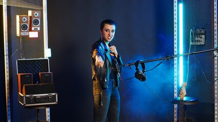Superstar female artist throwing air punches in celebration for something, rebellious confident...