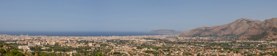 Fototapeta premium Panoramic view of Palermo city and mountains from Monreale town, Sicily, Italy, vast coastal cityscape framed by mountains in the background, coastline and urban landscape