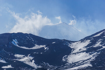 Beautiful detail view at the peak of Mount Etna Volcano covered in snow with clouds surrounding the summit, Catania, Sicily, Italy