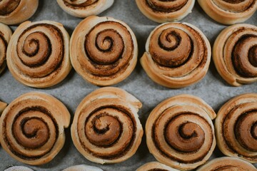 Close-up cinnabon buns freshly baked in the oven before applying cream in a cafe