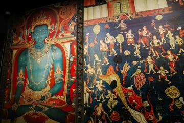 Colorful Thangka painting depicting a serene deity and intricate scenes, showcased at the Tibet Museum in Lhasa, Tibet, during a 2024 exhibition.