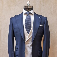 Elegant Formal Mannequin Displaying Tailored Suit with Stylish Tie and Crisp White Shirt Against Neutral Background