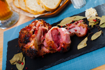 Freshly baked pork leg divided on pieces served with cheesy garlic sauce