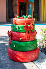 A stack of recycled automobile tires painted alternating red and green color. The tires have gold...