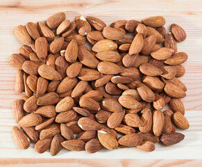 Obraz premium Heap of roasted almonds on wooden surface