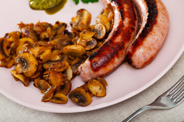 Spicy grilled sausages garnished with roasted mushrooms