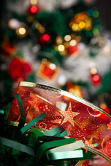 Christmas decoration detail. Red and gold, decorations such as ribbon, fir branches and pine cones.