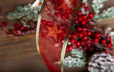 Christmas decoration detail. Red and gold, decorations such as ribbon, fir branches and pine cones.