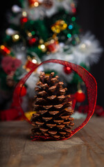 Christmas decoration detail. Red and gold, decorations such as ribbon, fir branches and pine cones.