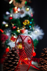 Christmas decoration detail. Red and gold, decorations such as ribbon, fir branches and pine cones.