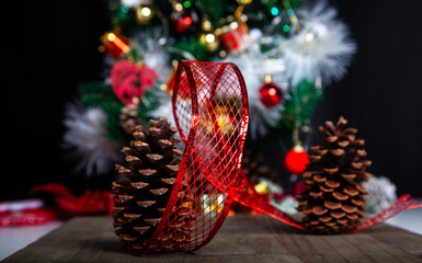 Christmas decoration detail. Red and gold, decorations such as ribbon, fir branches and pine cones.