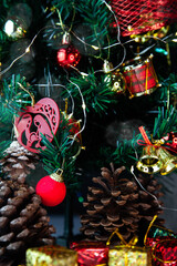 Christmas decoration detail. Red and gold, decorations such as ribbon, fir branches and pine cones.