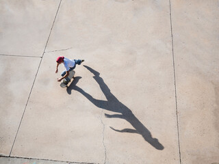 Young skateboarder practicing in urban skatepark on sunny day