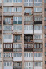 Fototapeta premium Facade of a brick multi-story apartment building with diverse loggias, one showing fire damage, in Saint Petersburg, Russia.