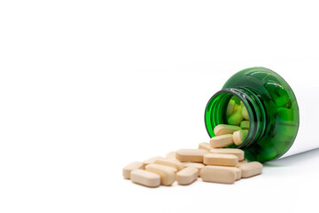 Front View Pills come out of a green medicine bottle. copy space selective focus isolated on white background