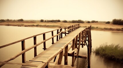 Obraz premium Rustic Wooden Bridge Spanning Calm Water In A Serene Landscape