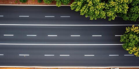 Overhead view of a black asphalt road with white dividing lines and trees on the side, white stripes, lanad