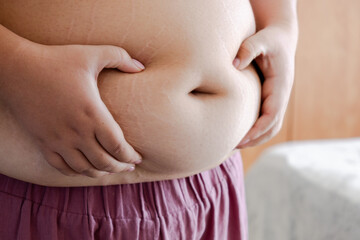 Realistic Plus-Size Woman Reflecting on Body Image in Home Setting.
A close up of a woman with...