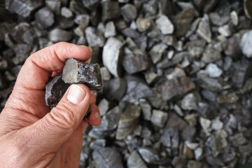 Hand holding a piece of galena ore mined for lead and silver. Lead is used in radiation protection,...