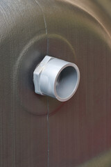 close-up of pvc overflow pipe on black textured water tank, soft focus with copy space