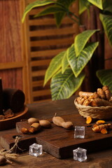 turmeric tamarind herbal drink in a plastic bottle, and turmeric on a plain black background